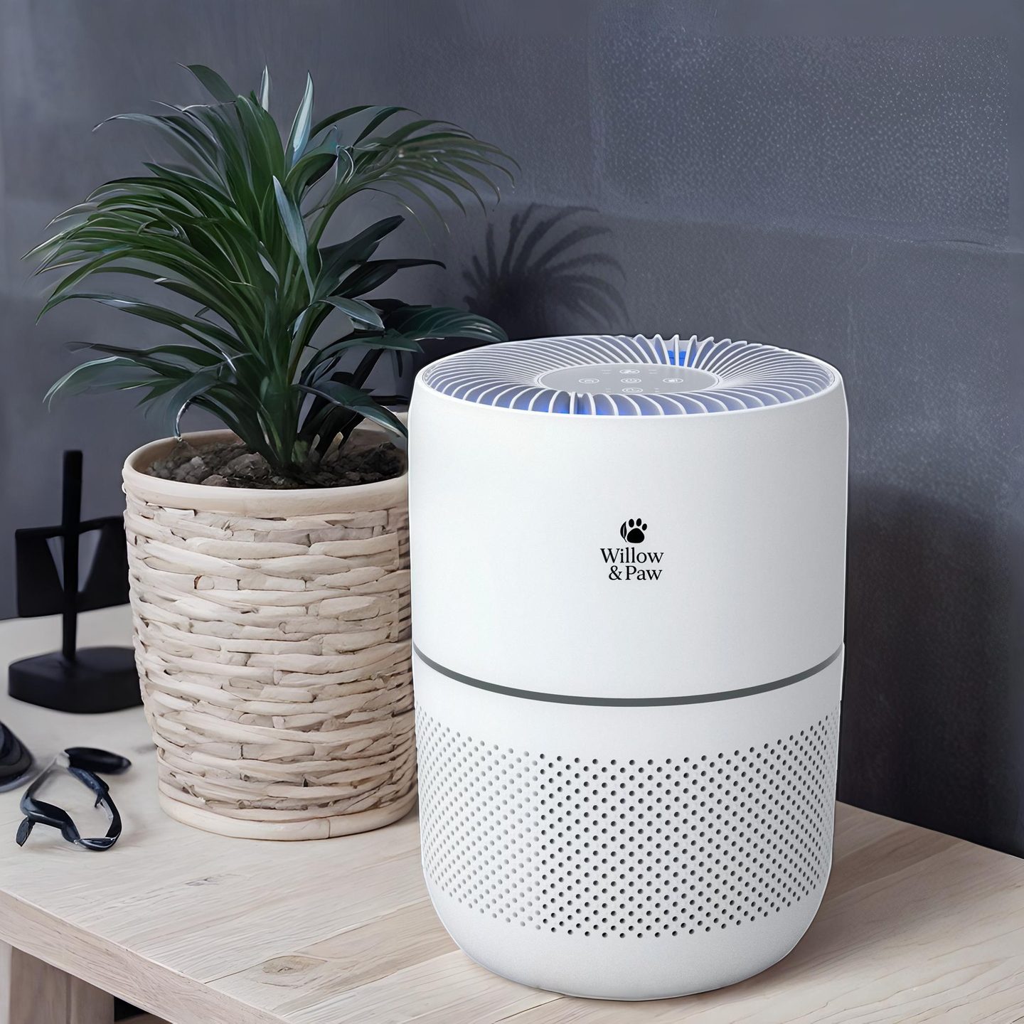 The white purifier on a wooden side table next to a potted plant